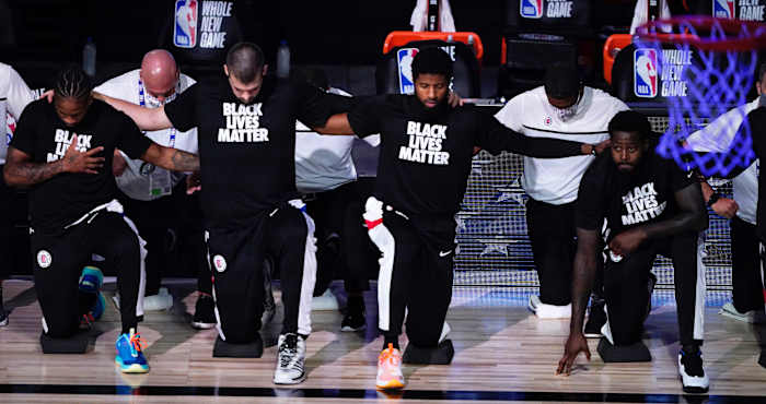 Los Angeles Clippers players kneel in honor of the Black Lives Matter movement during the playing of the national anthem prior to an NBA basketball game